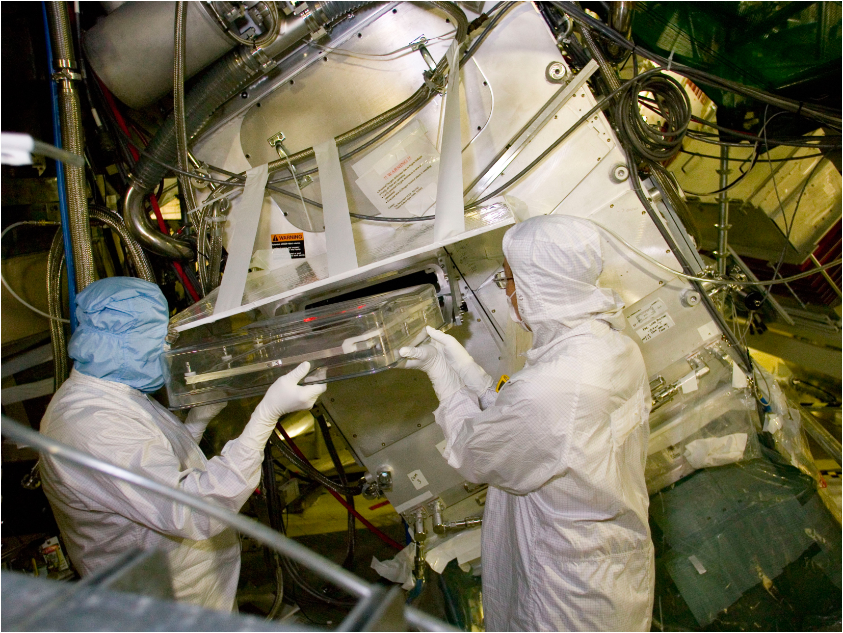Technicians installing a debris shield in a NIF final optics assembly