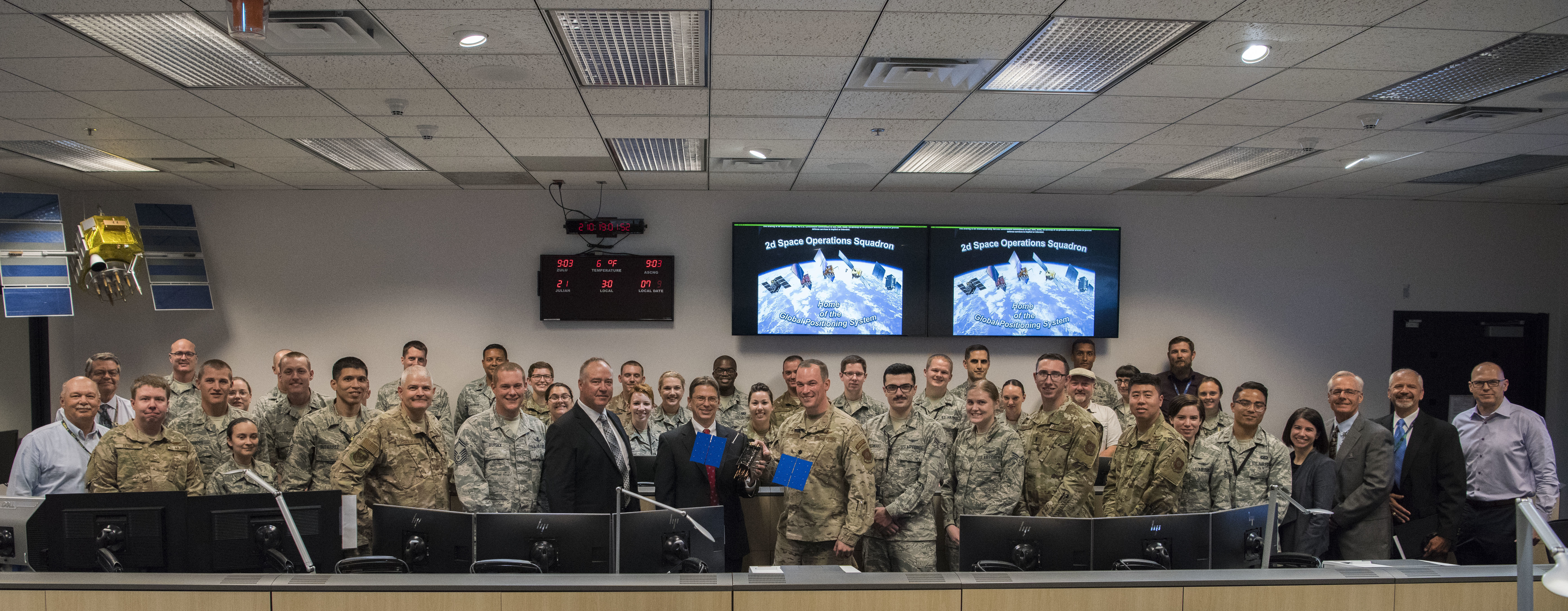 A GPS III model satellite is presented at Schriever Air Force Base