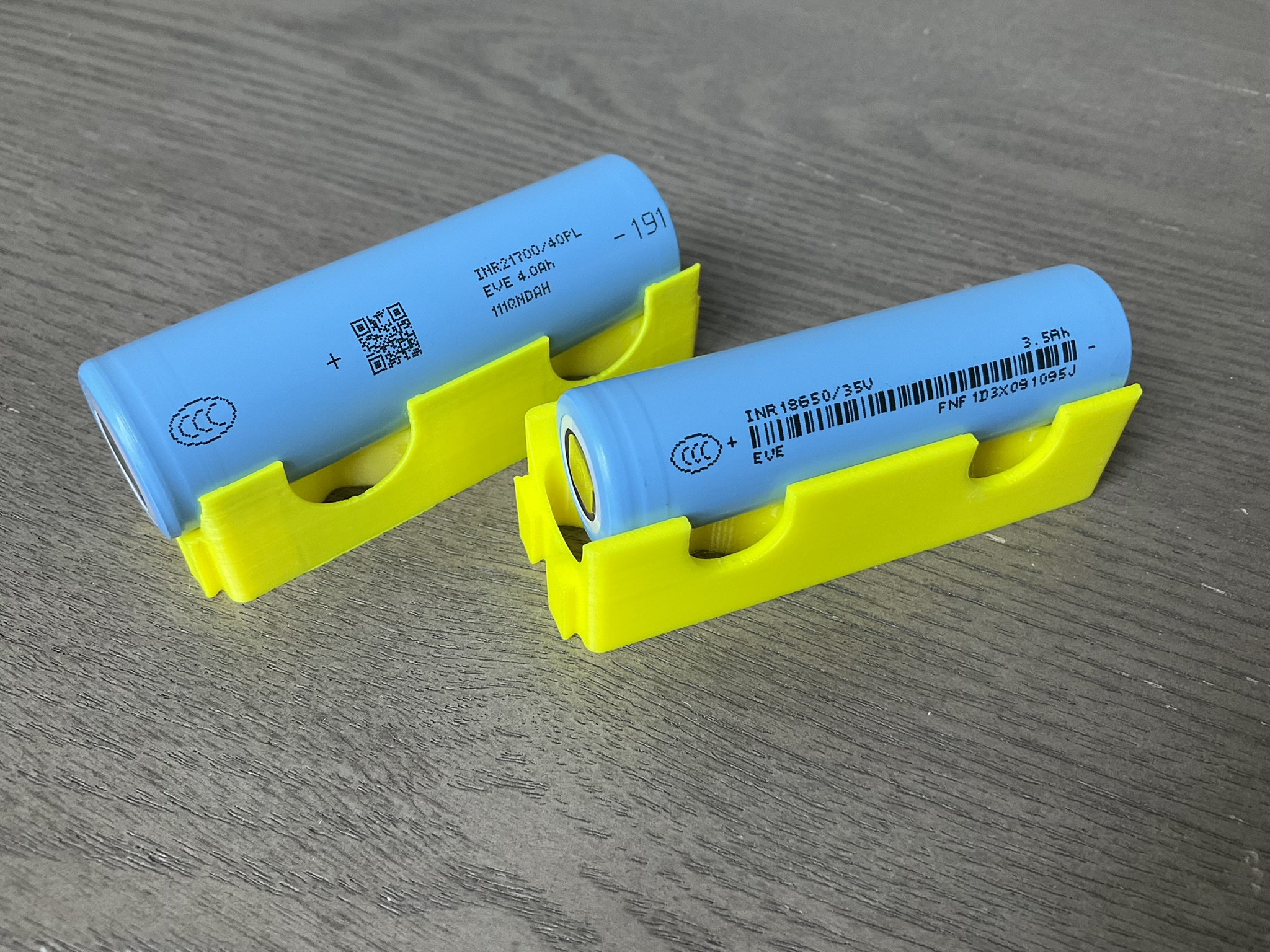 Two cylindrical lithium-ion battery cells, 18650 and 21700 formats